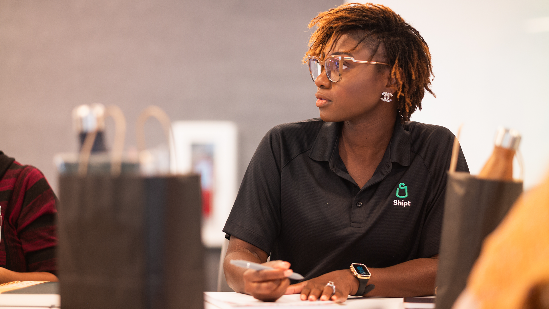 A Shipt employee sits at a table attentively, engaging in learning