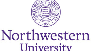 A person with electrodes on their face sits smiling, surrounded by three others, including one holding wires, in a room with a relaxed atmosphere.