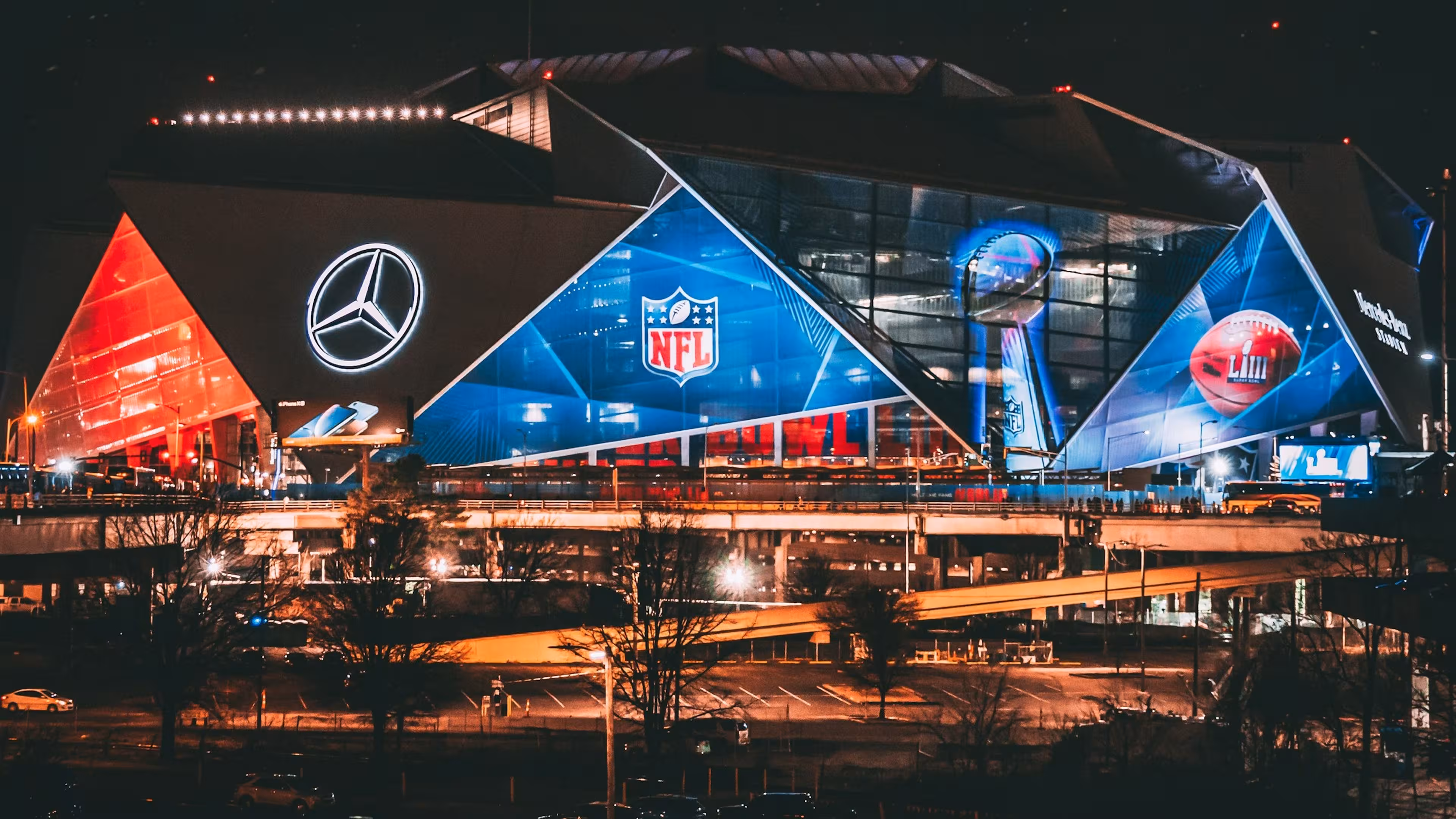 Image of Mercedes Benz Stadium during a NFL game night with the surrounding parking spots.