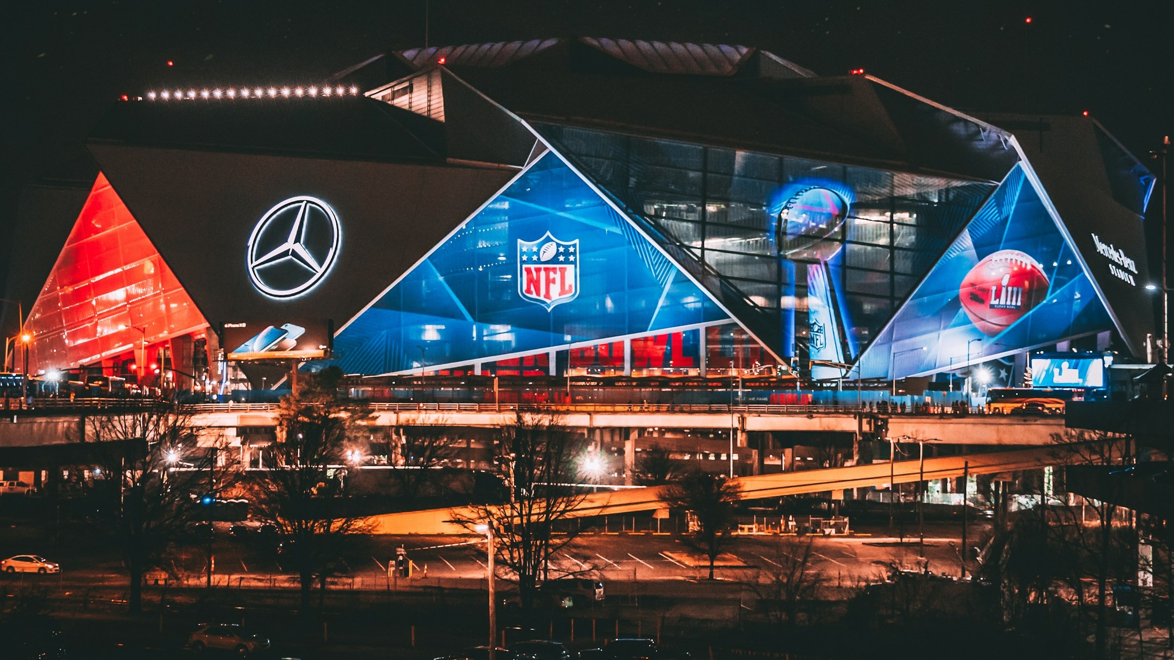 Image of Mercedes Benz Stadium during a NFL game night with the surrounding parking spots.