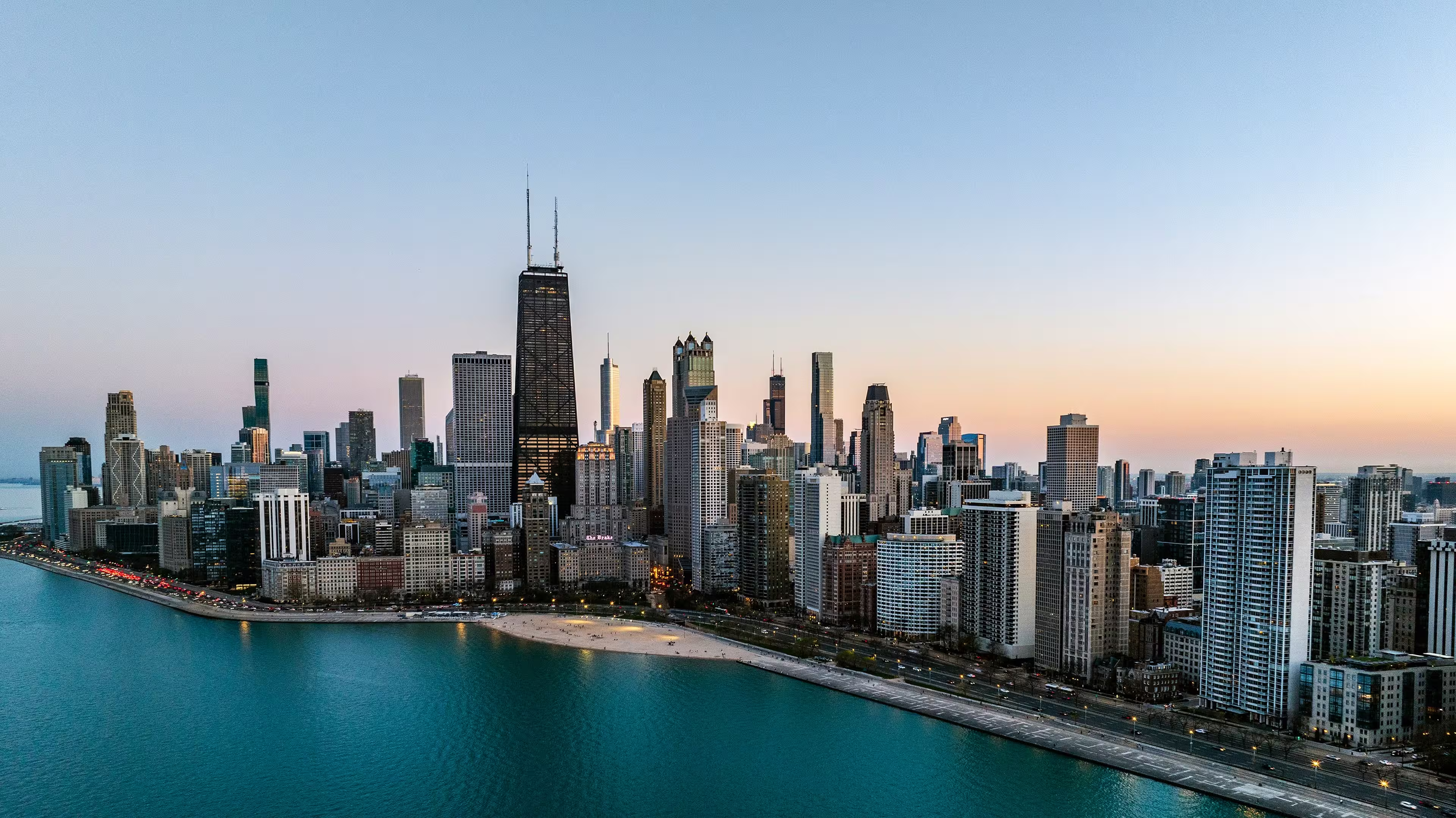 Aerial view of downtown Chicago, Illinois, with skyscrapers along Lake Michigan at sunset.