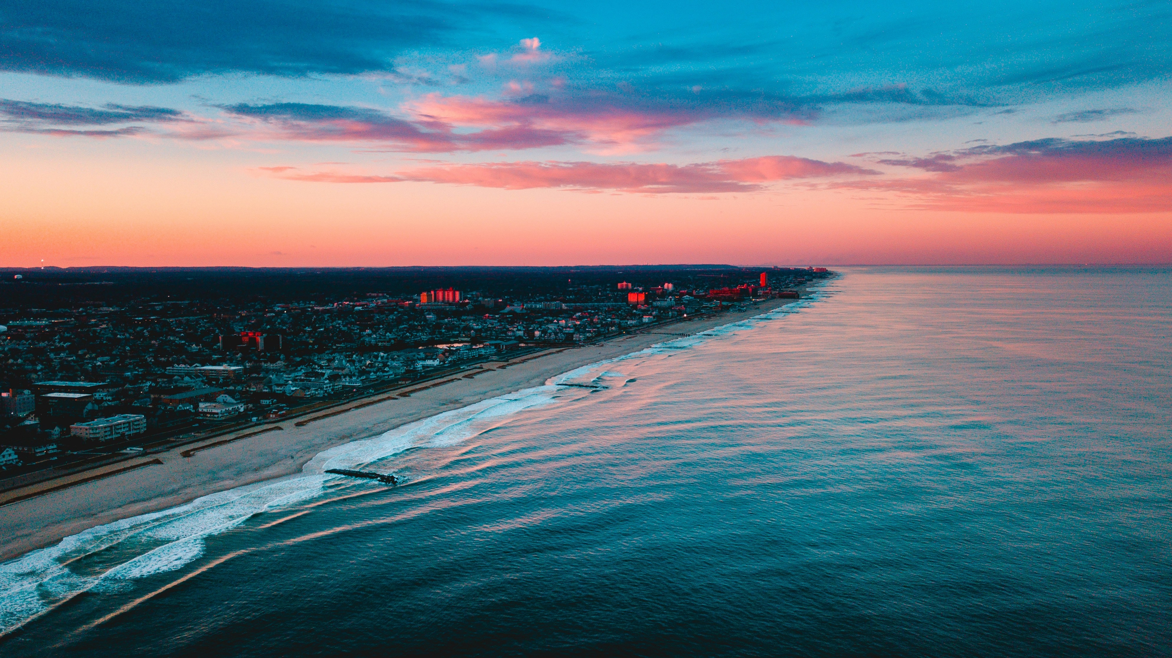 Aerial view of the Asbury Park coastline at sunset in New Jersey, with waves hitting the shore