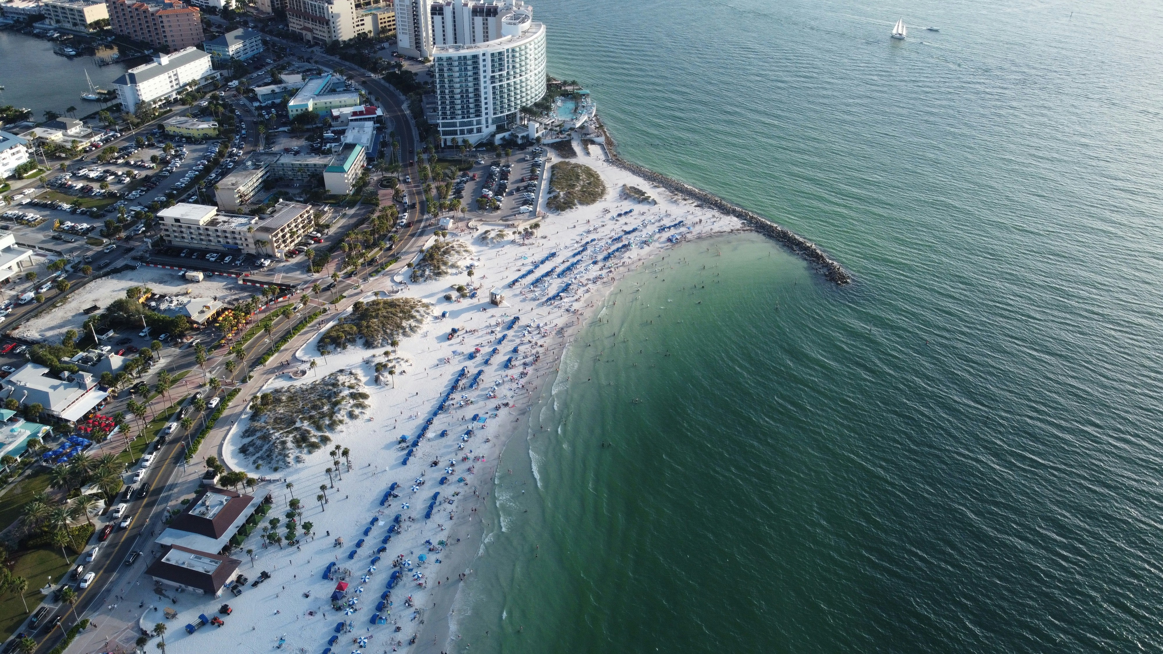 Aerial view of Clearwater beach, Florida with white sand, turquoise water and nearby buildings along the shoreline.