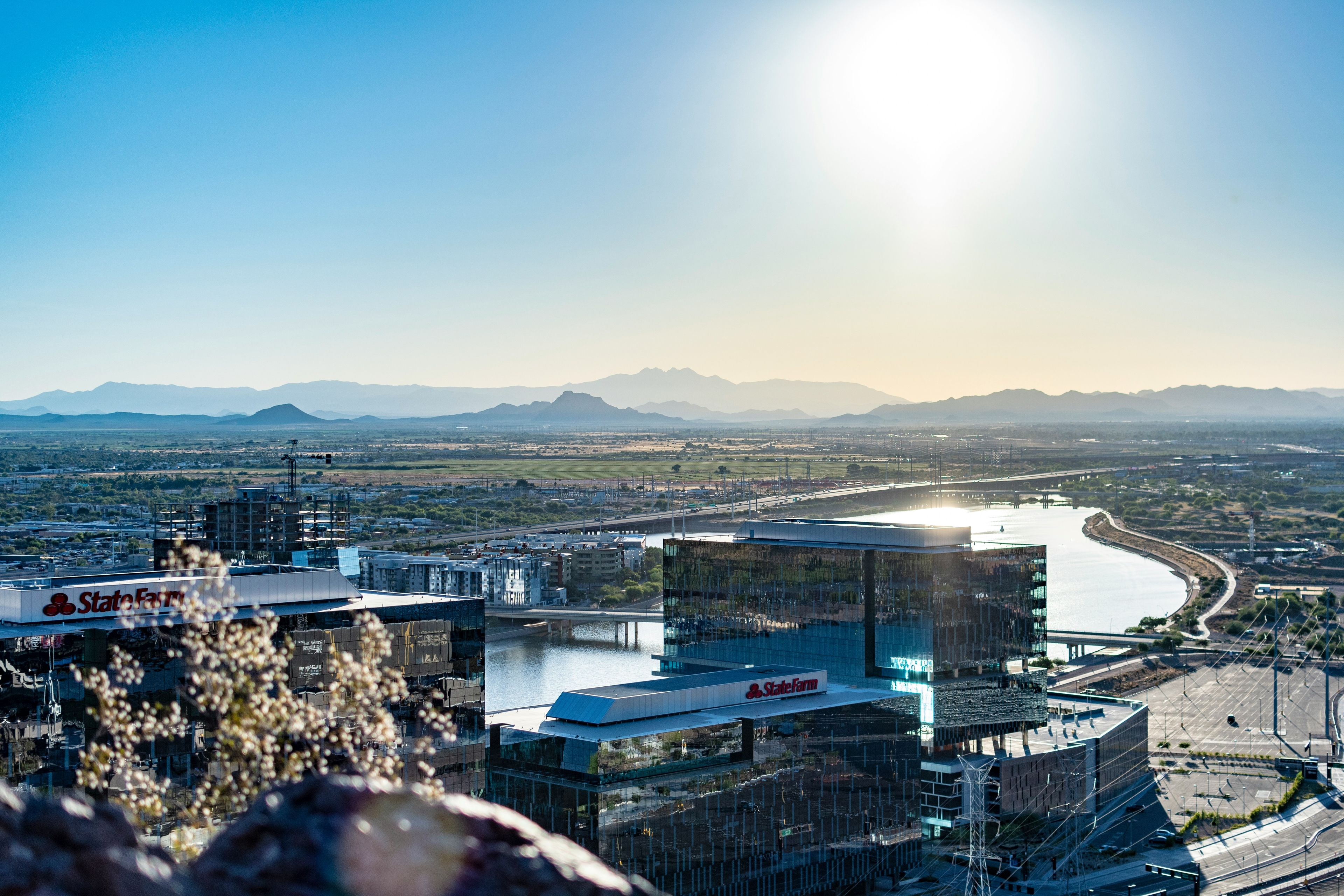 Panoramic view of Tempe, Arizona, with modern buildings by the river and mountains in the background.