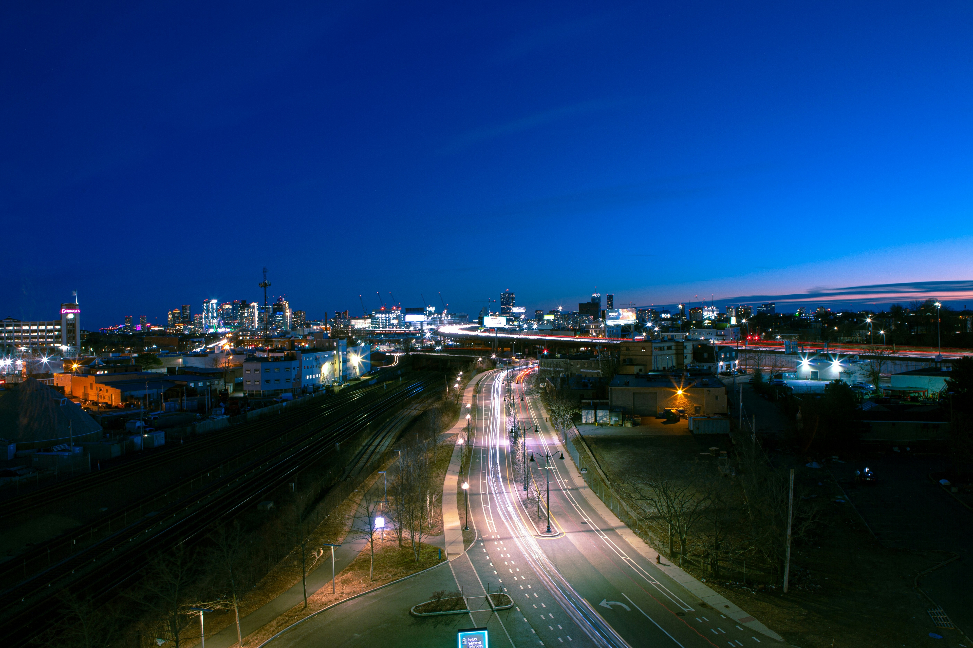 Somerville at dusk with illuminated roads and buildings under a deep blue sky.