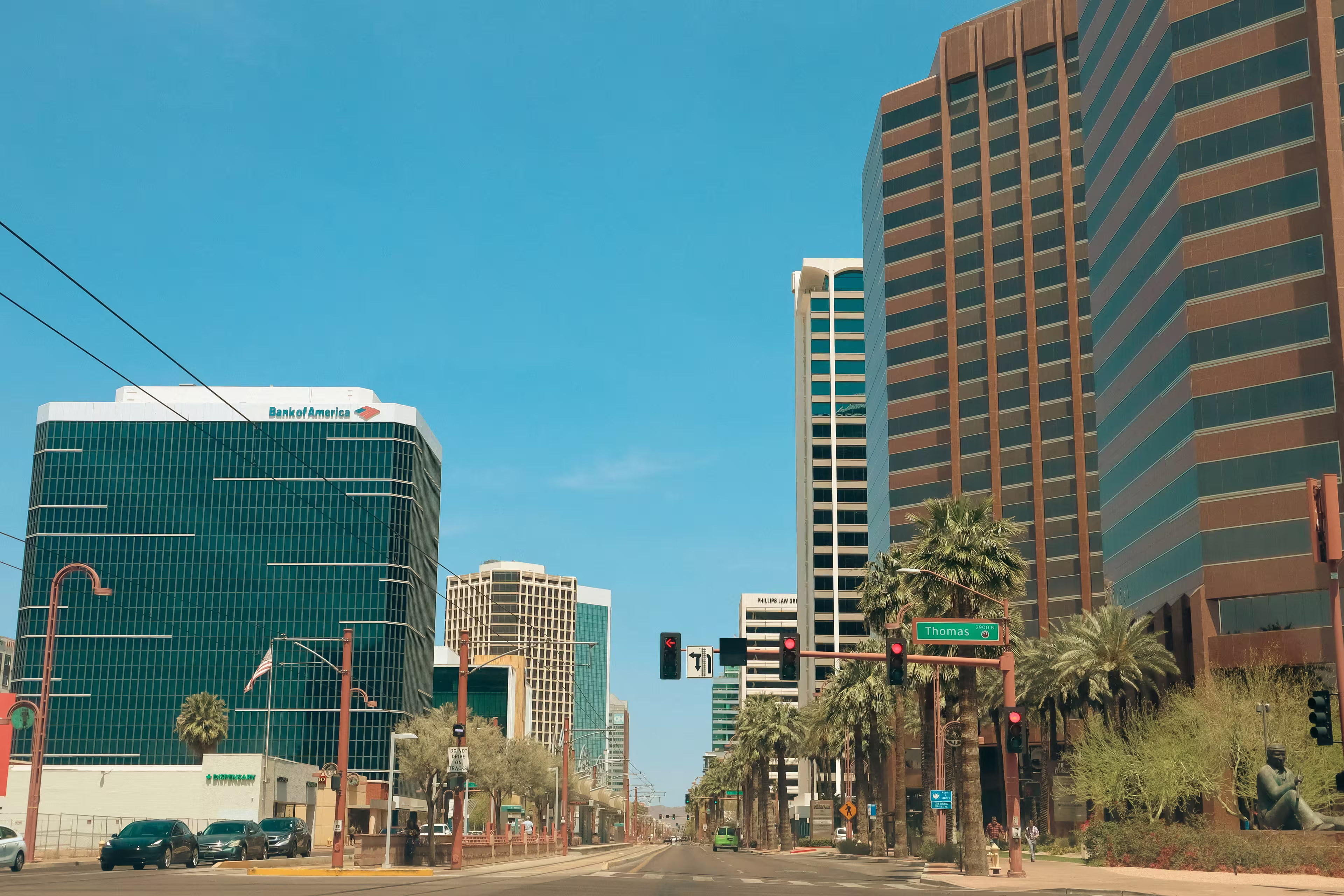 Downtown Phoenix, Arizona, with tall buildings and palm trees under a clear blue sky.