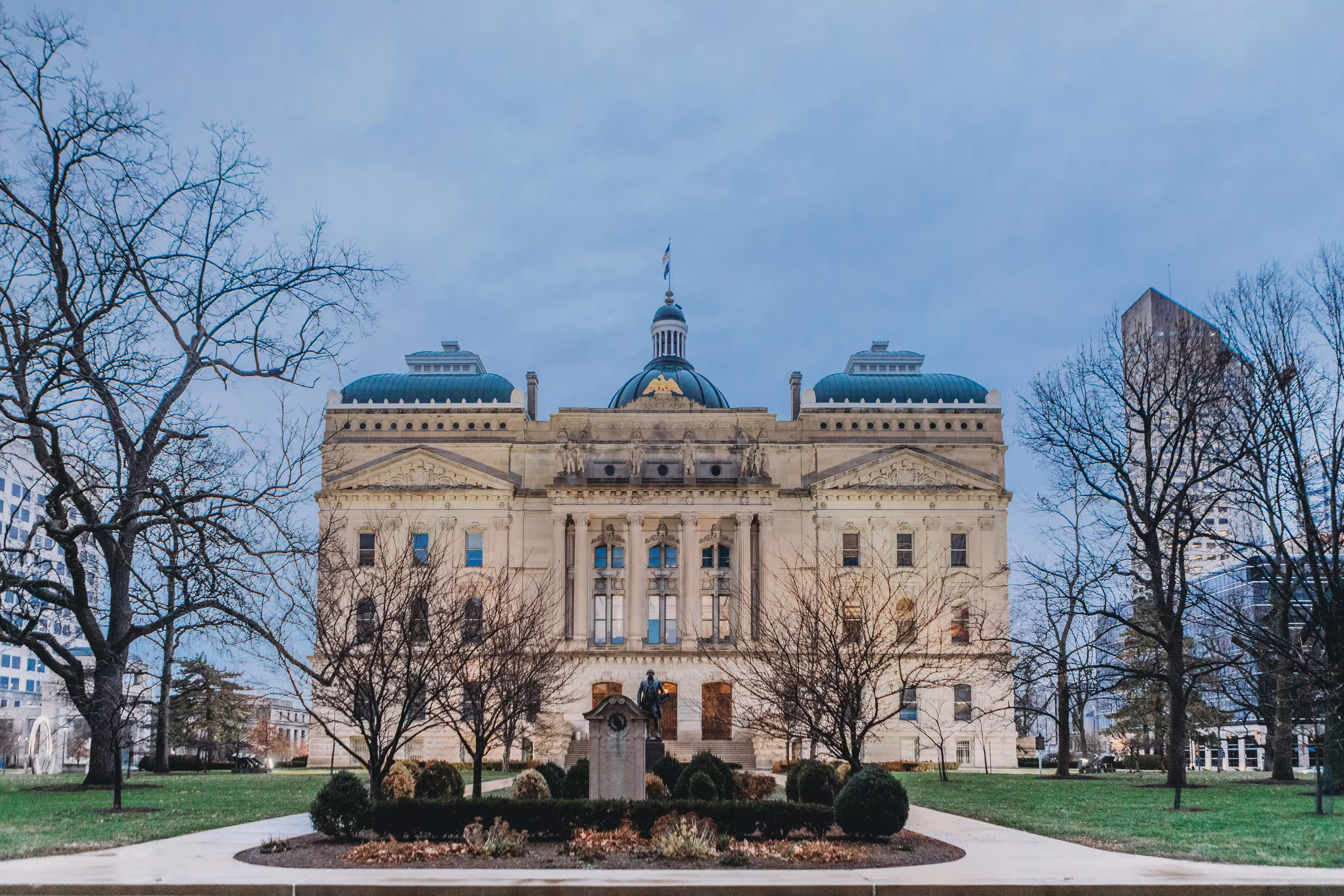Front view of the Indiana State Capitol building in downtown Indianapolis, Indiana, on a cloudy day.