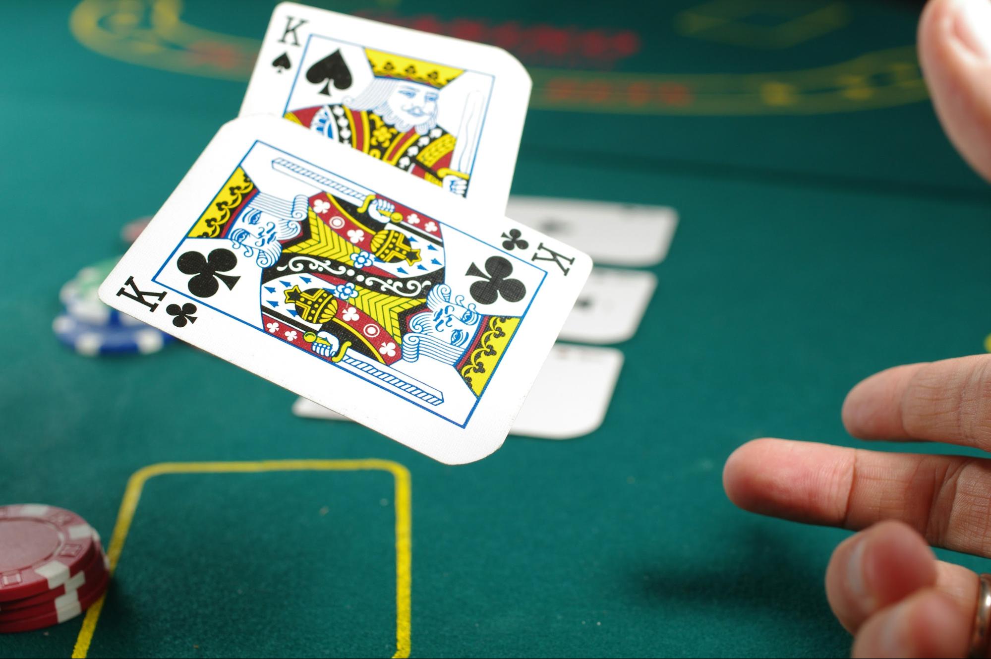 A poker player is revealing the two kings in their hand while practicing their poker bluff catcher strategy.