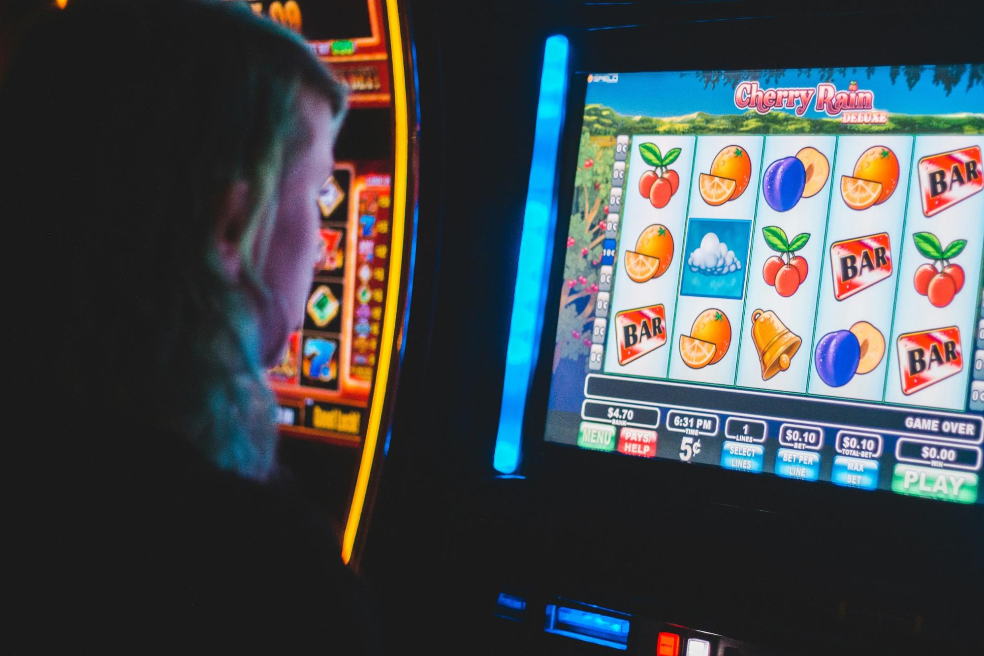 A woman is playing a slot machine game and practicing responsible gaming in New Hampshire.