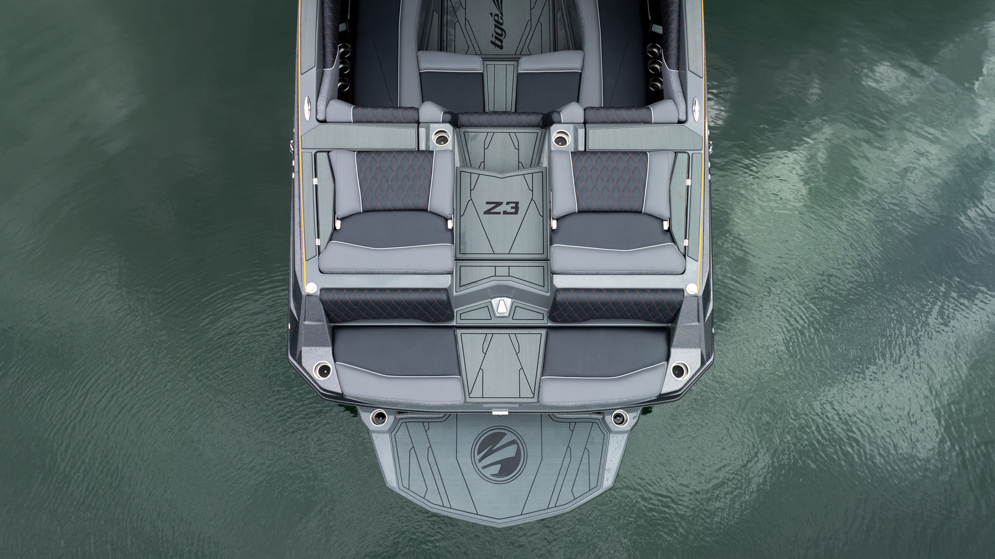 Top view of the transom and swim platform of a 2026 Tige Z3 boat with gray seating and a Z3 logo, floating on calm green water.