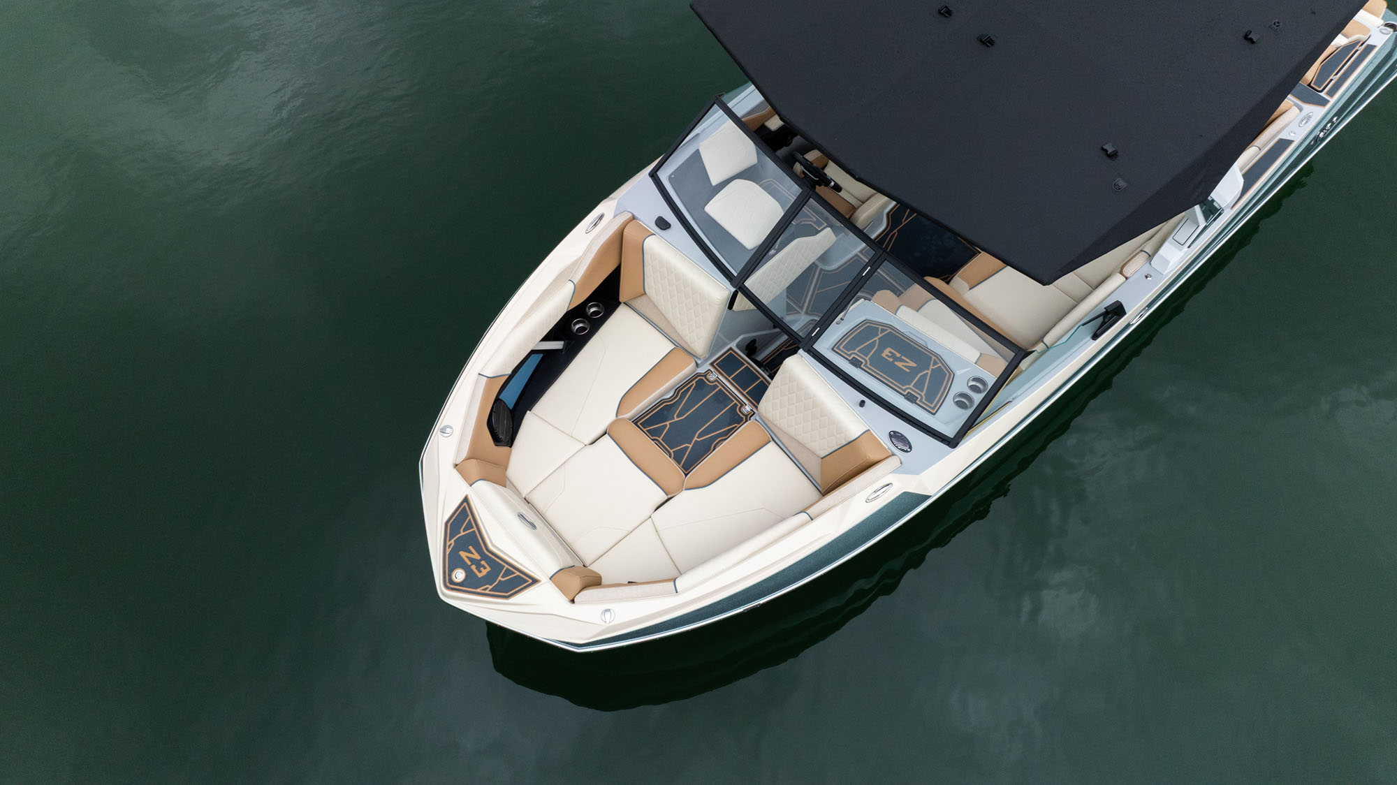 Aerial view of a sleek 2026 Tige Z3 with beige seating, floating on calm green water.