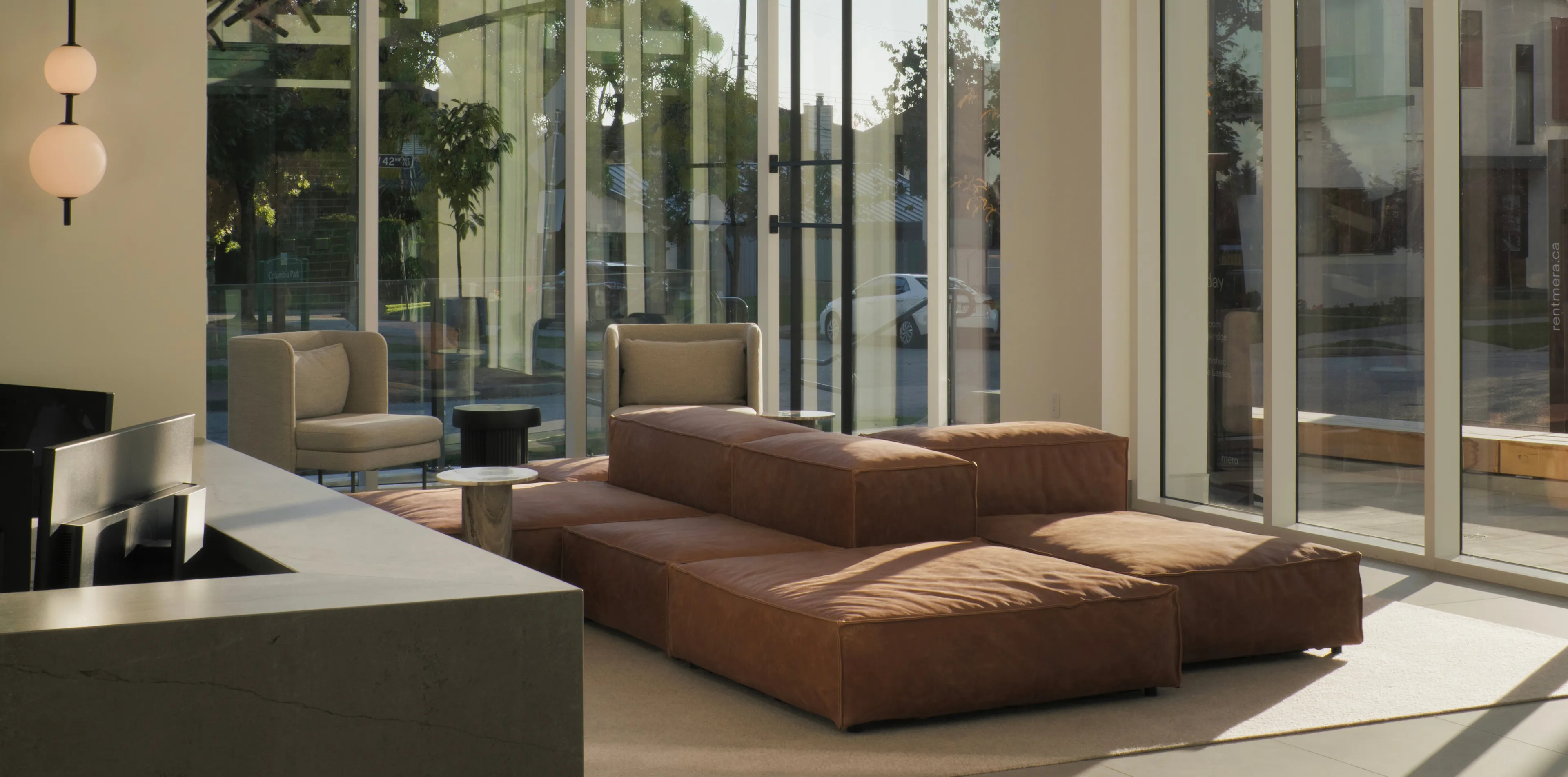 Modern living room with large leather sectional sofa, beige armchairs, and glass walls letting in natural light. Minimalistic decor with soft lighting.