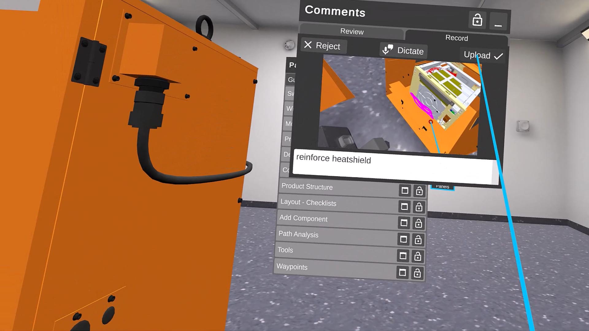 A virtual reality interface showing an orange machine and a screen with a 3D model labeled "reinforce heatshield" in a workshop setting.