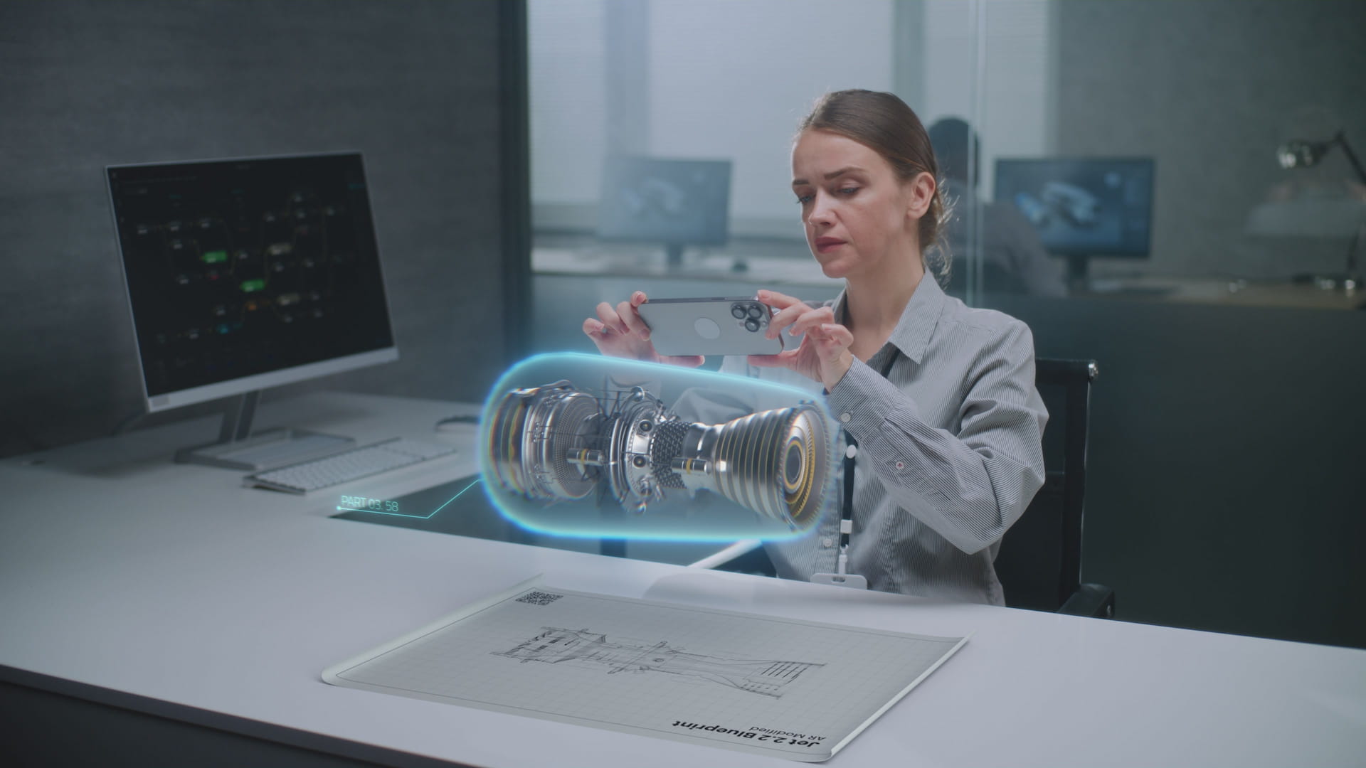 Female engineer uses smartphone to visualize 3D engine model.