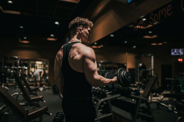 A lifter holding dumbbells at shoulder height