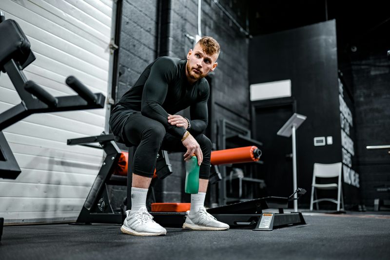 man sitting in gym - Weighted Dips Strength Standards