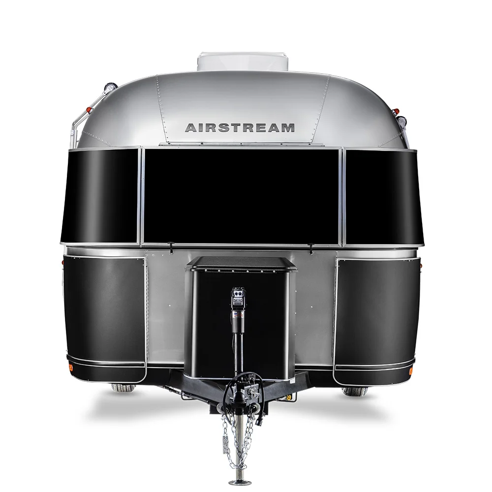 Front view of a sleek Airstream trailer with a shiny metallic finish, featuring large windows and a central hitch at the bottom.