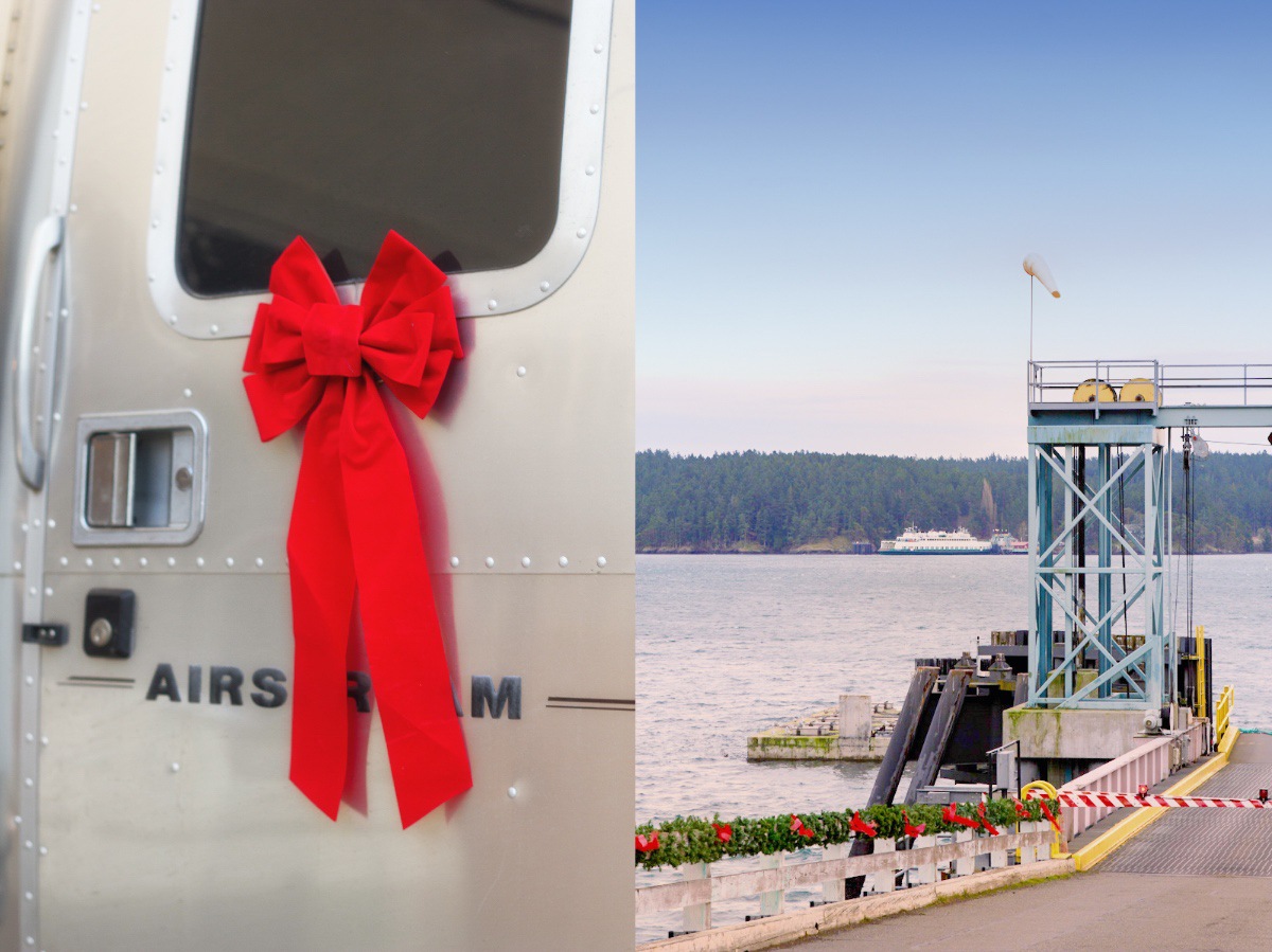 A shiny Airstream trailer decorated with a large red bow is on the left; on the right, a ferry dock extends into calm water, with trees and a ferry in the background under a blue sky.