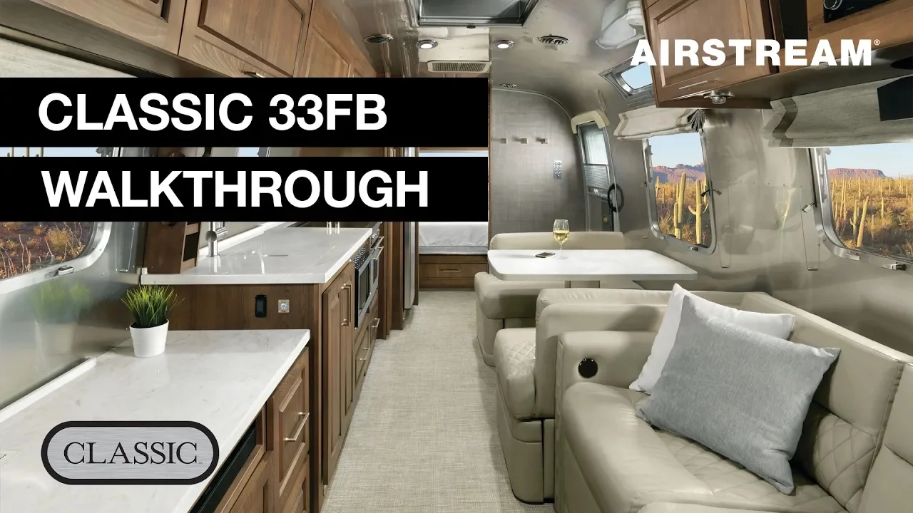 Interior of an Airstream Classic 33FB, featuring a modern kitchen, dining area, and lounge with large windows. Text reads "Classic 33FB Walkthrough."