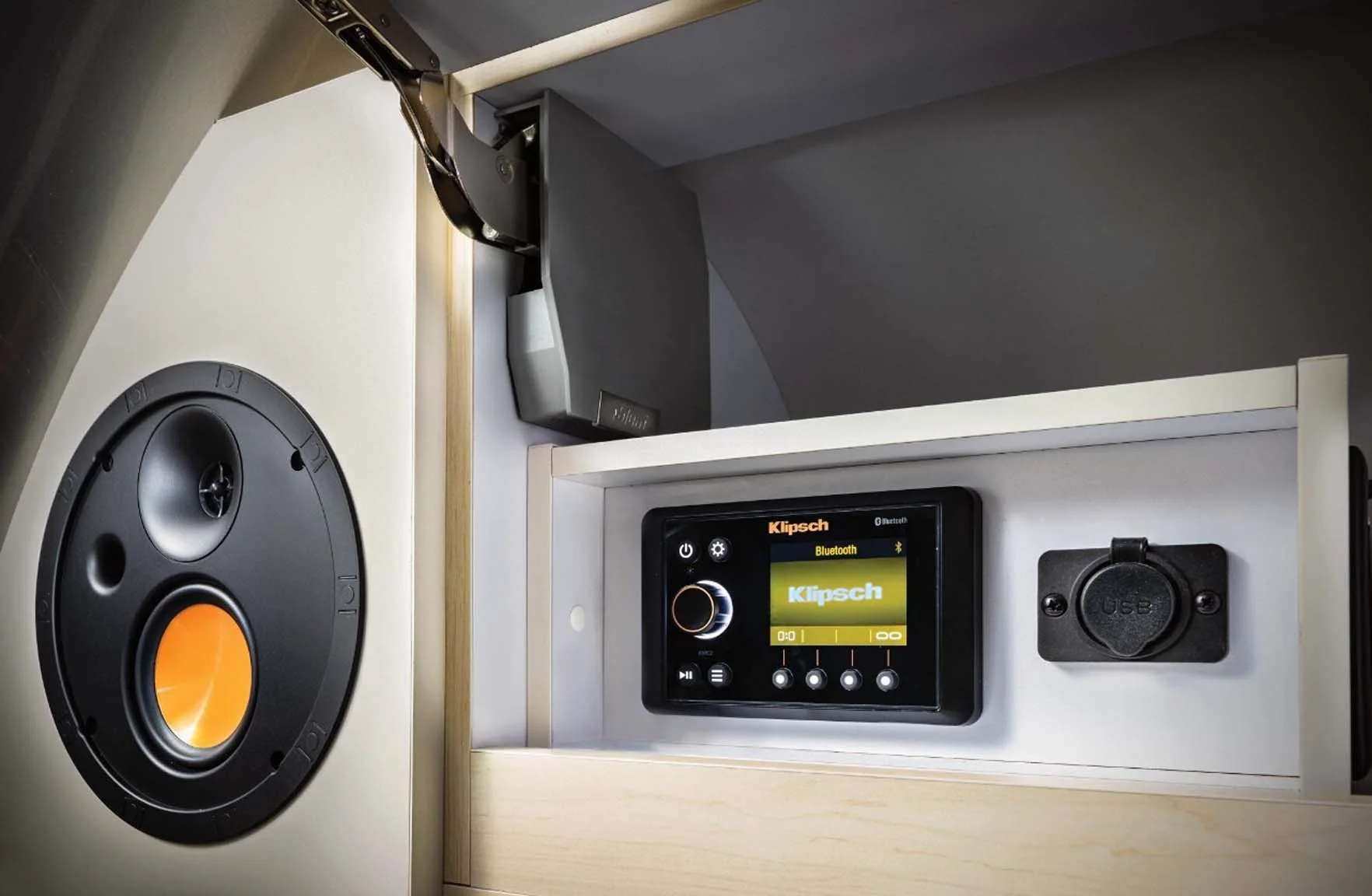 Audio system setup with Klipsch speaker, Bluetooth stereo display, and USB port in a sleek wooden cabinet.
