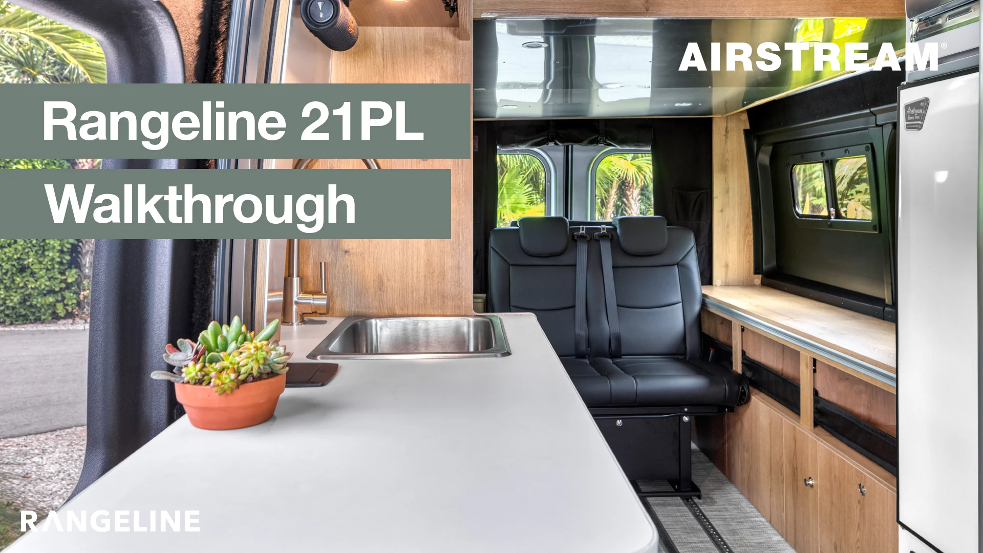 Interior of an Airstream Rangeline 21PL featuring a sink, countertop, leather seats, and wooden cabinetry, with text "Rangeline 21PL Walkthrough."