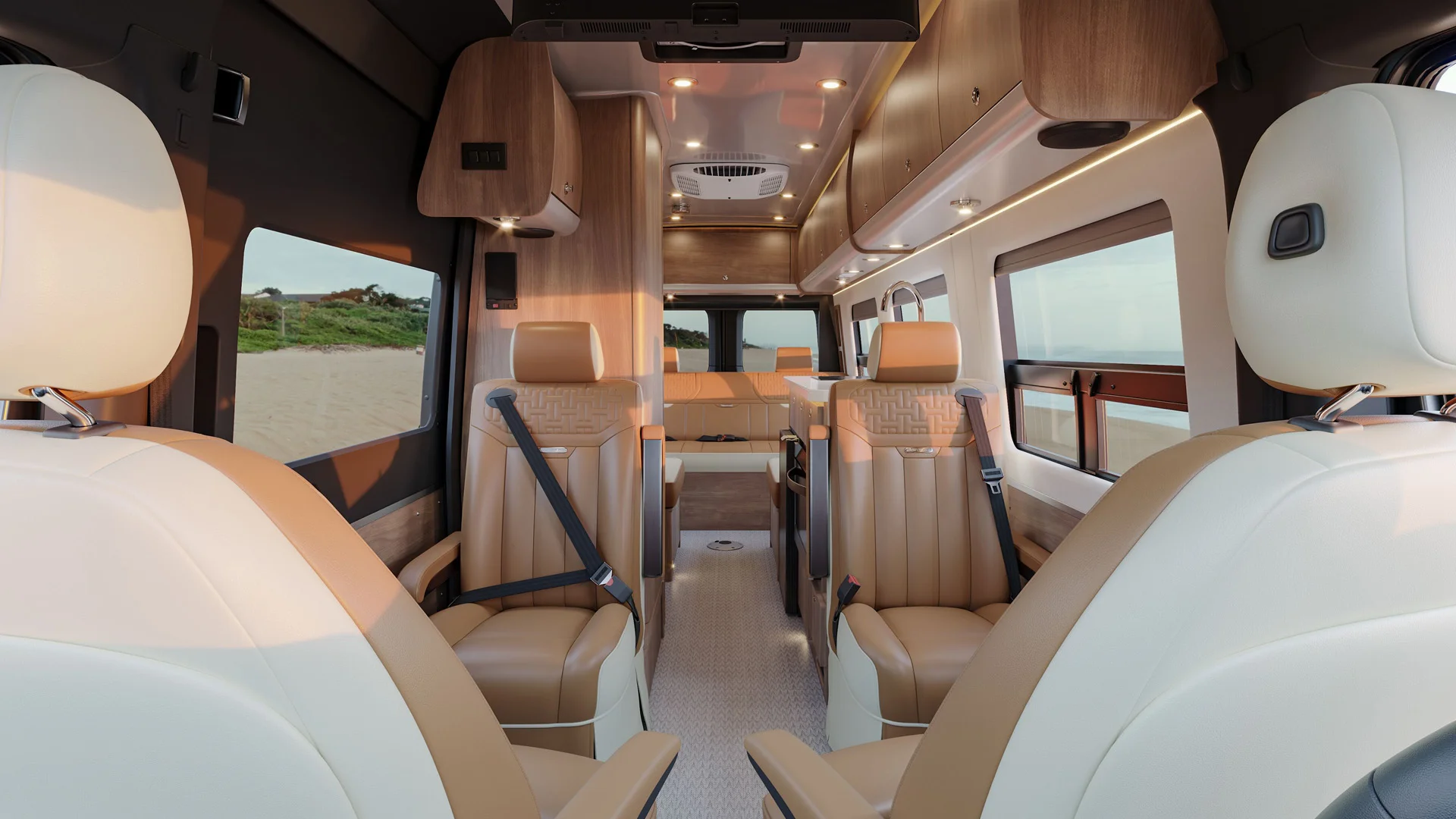 Interior of a modern camper van with cream and tan leather seats, wood accents, and ambient lighting, offering a spacious and luxurious feel.