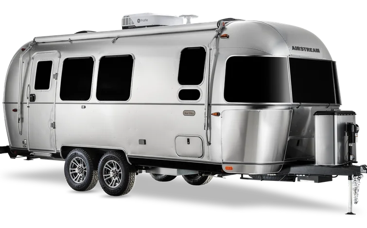Silver Airstream travel trailer with rounded edges, large windows, and twin axles, shown on a white background.