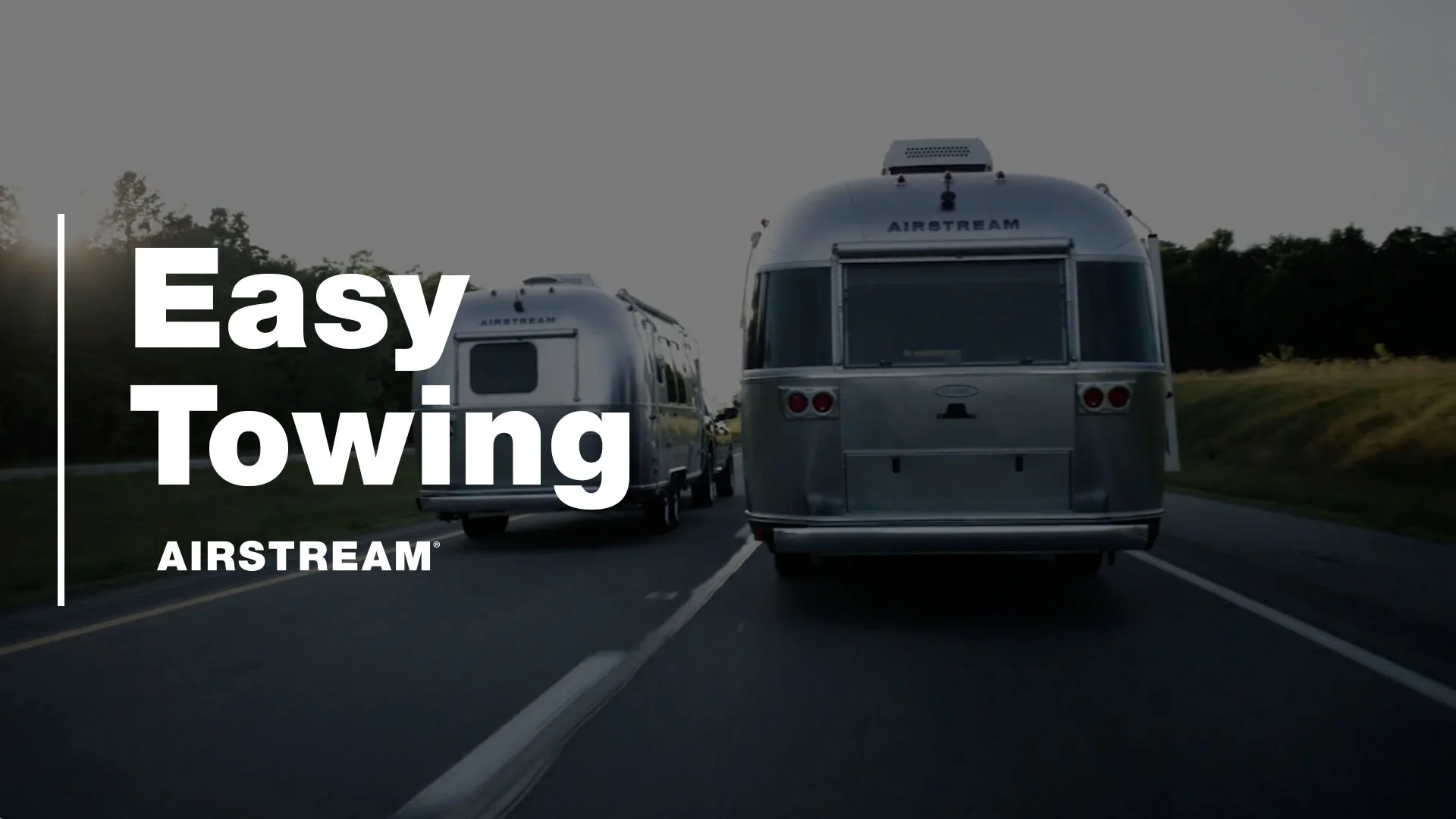 Two Airstream trailers being towed on a highway with trees in the background. Text reads "Easy Towing AIRSTREAM."