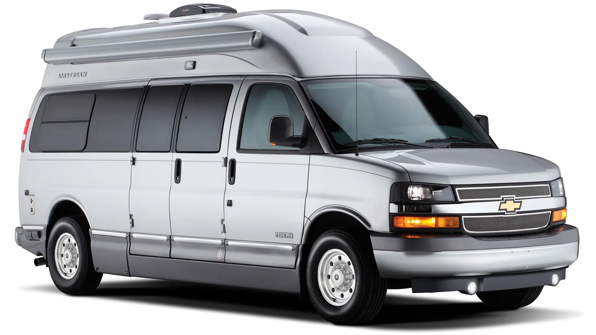 Silver Chevrolet camper van with tinted windows and rooftop equipment, parked on a white background.