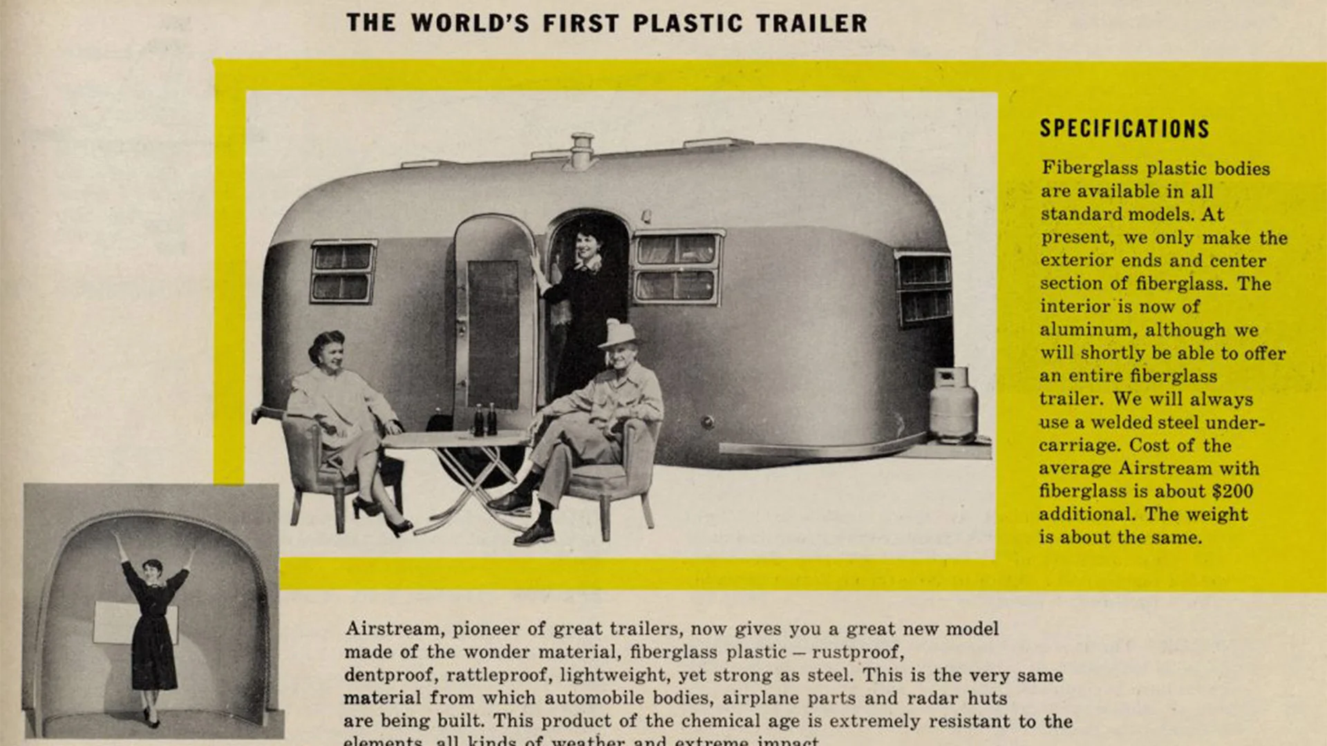 Black and white photo of a vintage plastic trailer with two people seated outside and one standing in the doorway. Specifications text on the side.