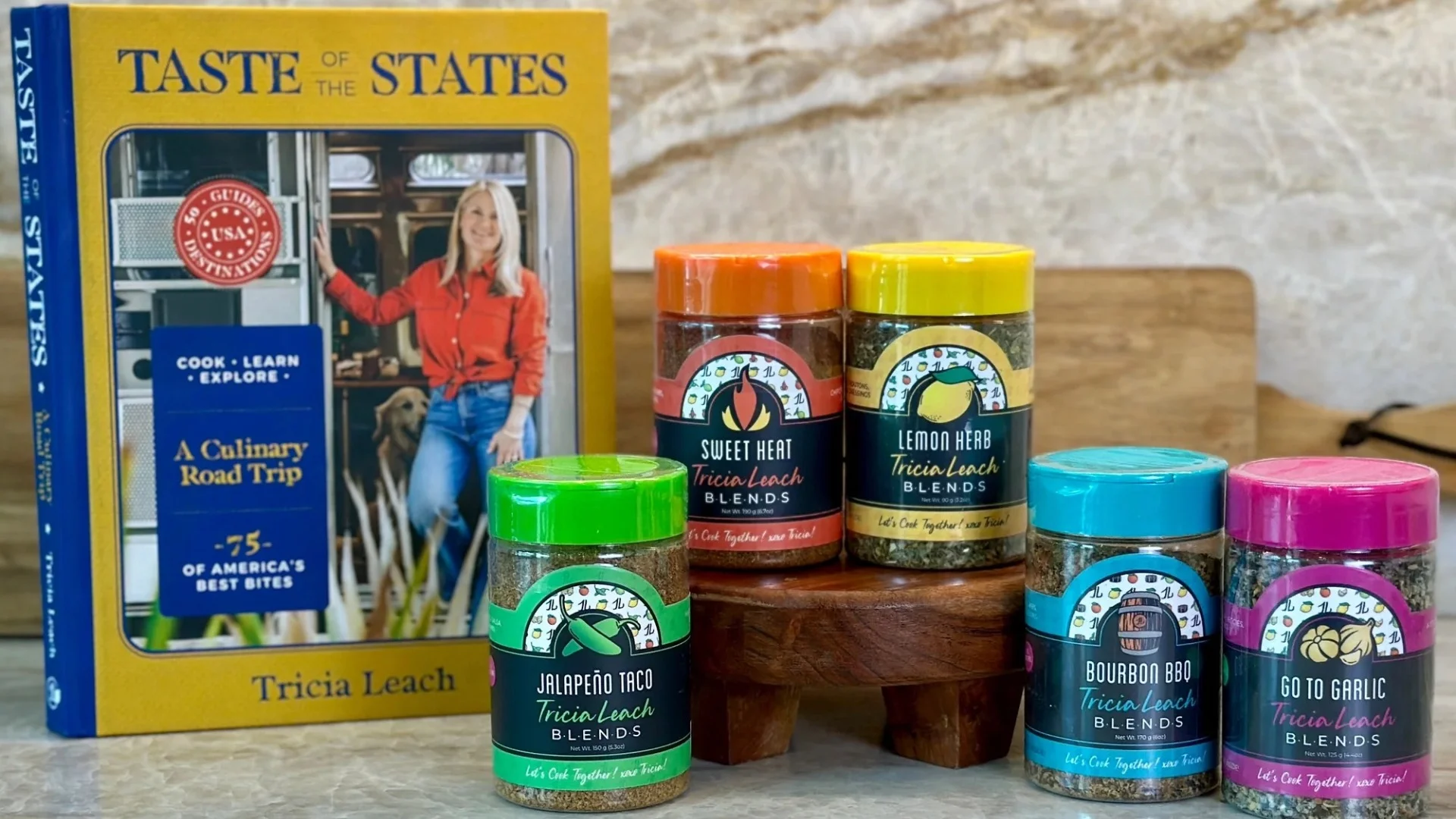 "Taste of the States book by Tricia Leach alongside five spice blends: Jalapeño Taco, Sweet Heat, Lemon Herb, Bourbon BBQ, and Go to Garlic."