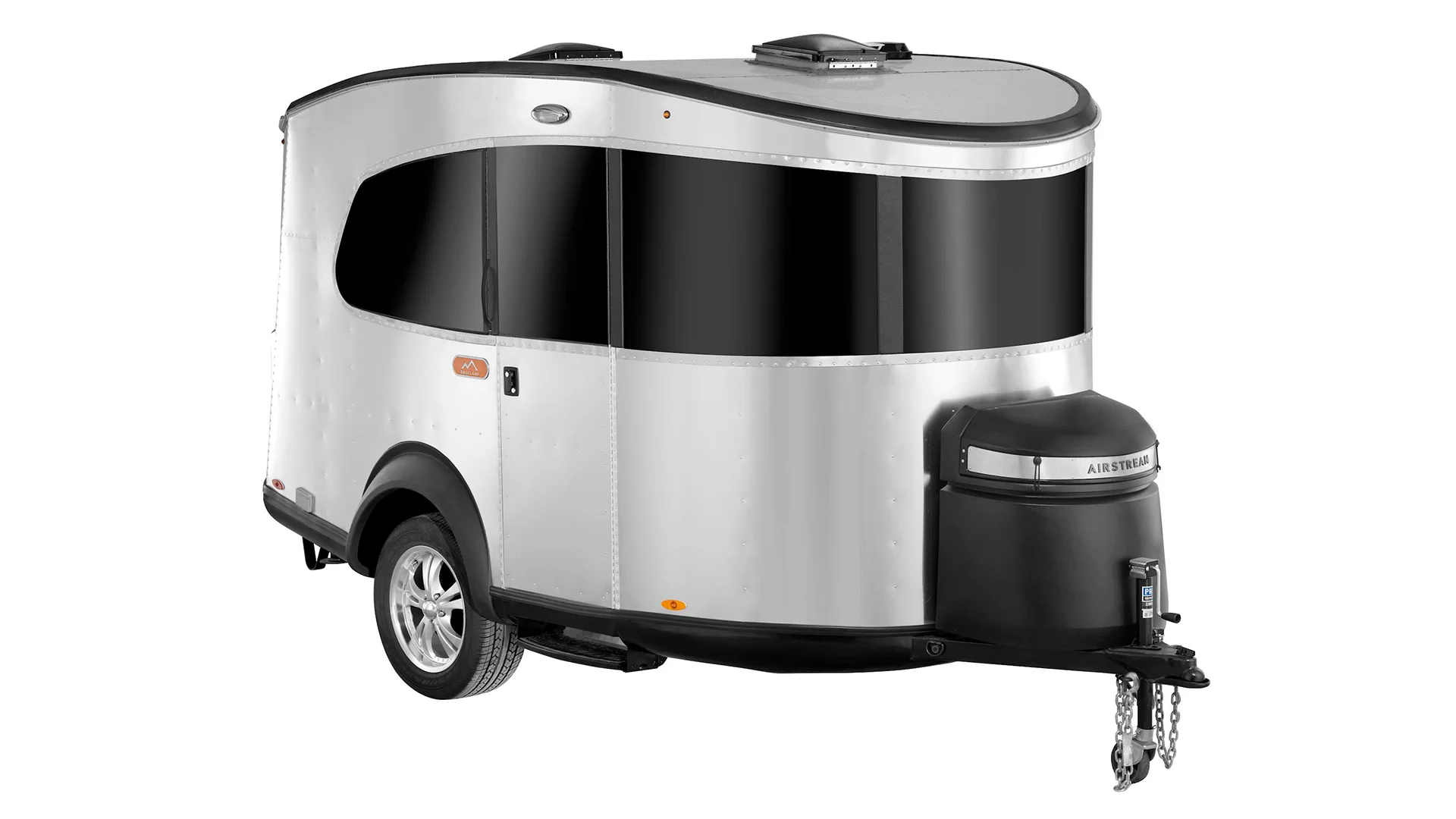 Silver and black travel trailer with rounded edges, featuring tinted windows, and a hitch for towing.