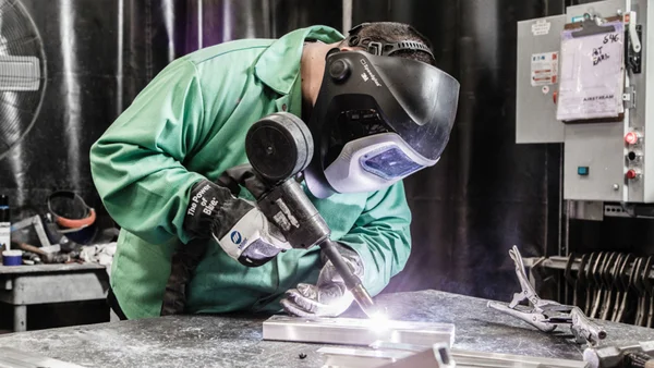 Airstream craftsperson welding an aluminum shell in the factory