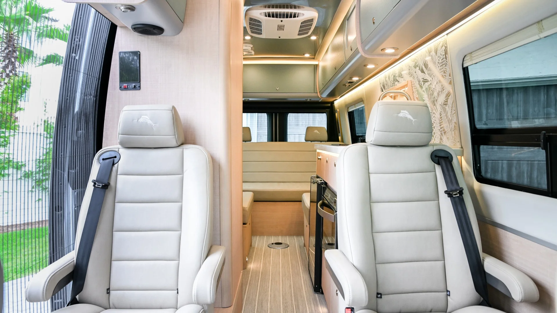 Camper van Tommy Bahama captains chairs and cream-colored couch behind them