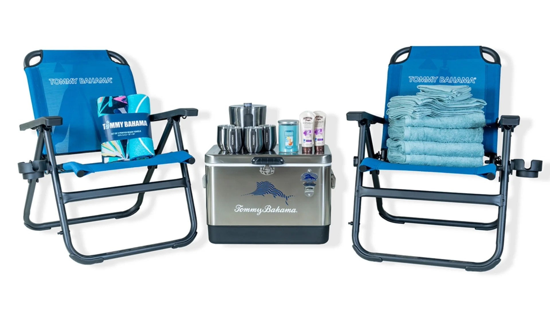 Blue Tommy Bahama beach chairs, cooler with logo, folded towels, and assorted drink tumblers displayed on a white background.