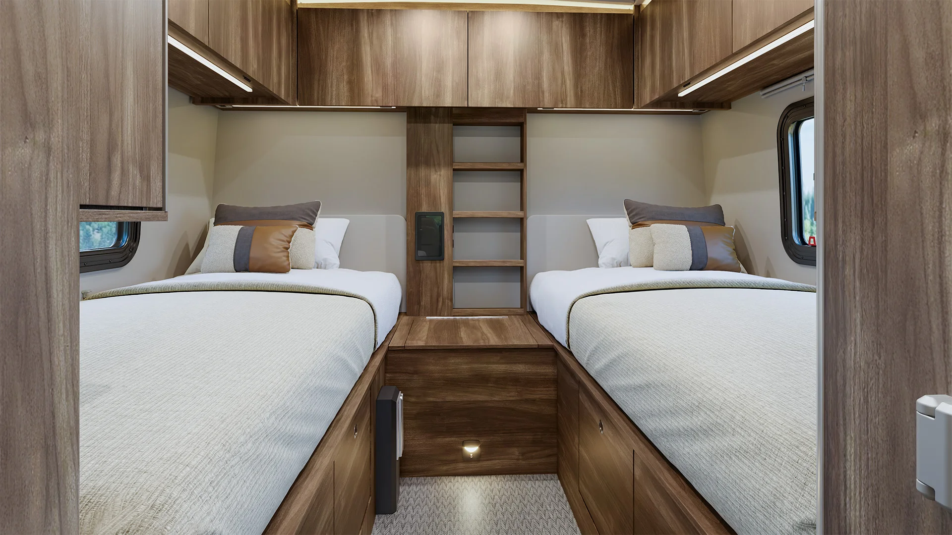 Interior of an RV bedroom with twin beds, wooden cabinets, and a central shelf. Soft lighting and windows create a cozy atmosphere.