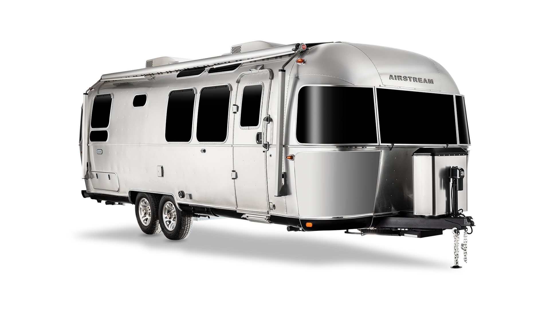 Silver Airstream travel trailer with rounded edges, windows, and dual axles on a white background, showcasing modern design.