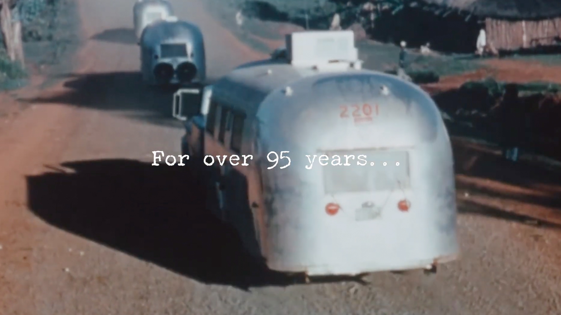 Vintage Airstream trailers traveling on a rural road with the text "For over 95 years..." overlayed.