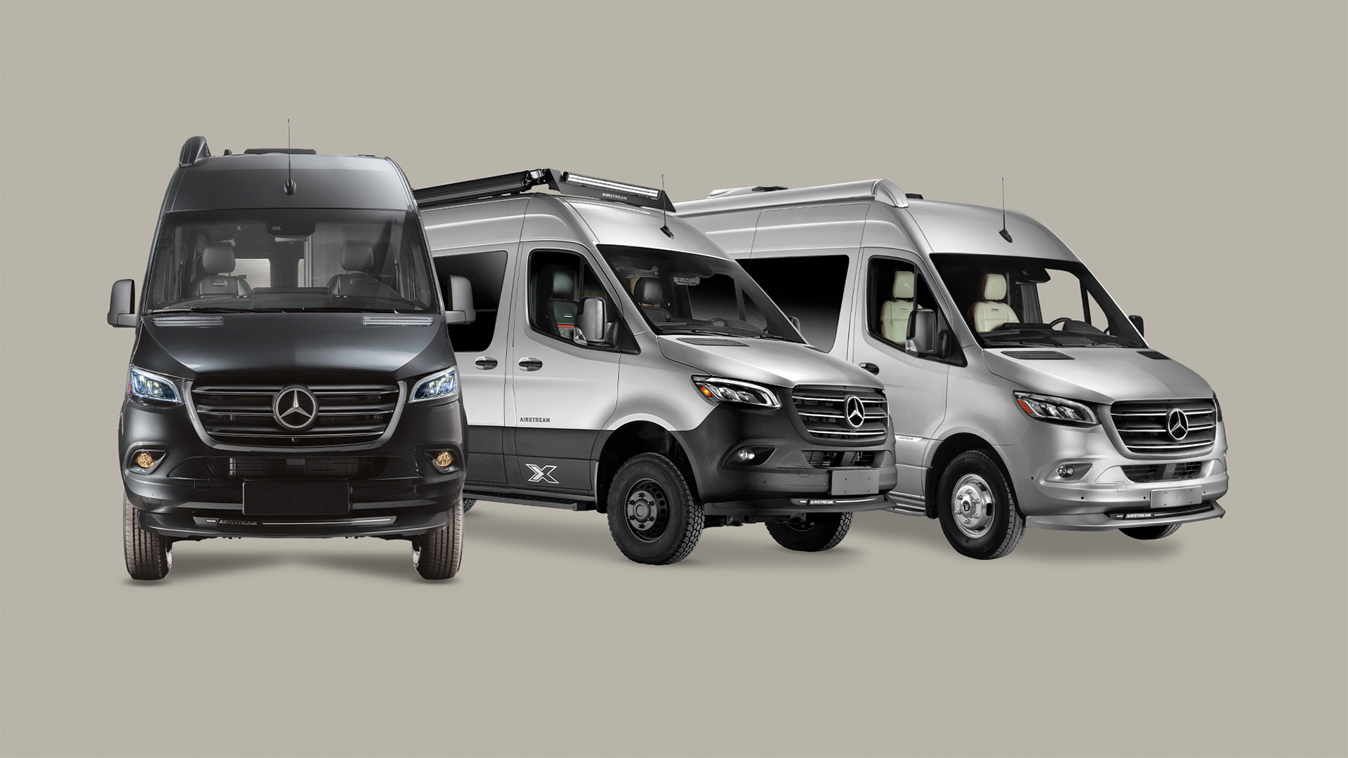 Three Mercedes-Benz vans in black, white, and silver, parked side by side on a neutral background.