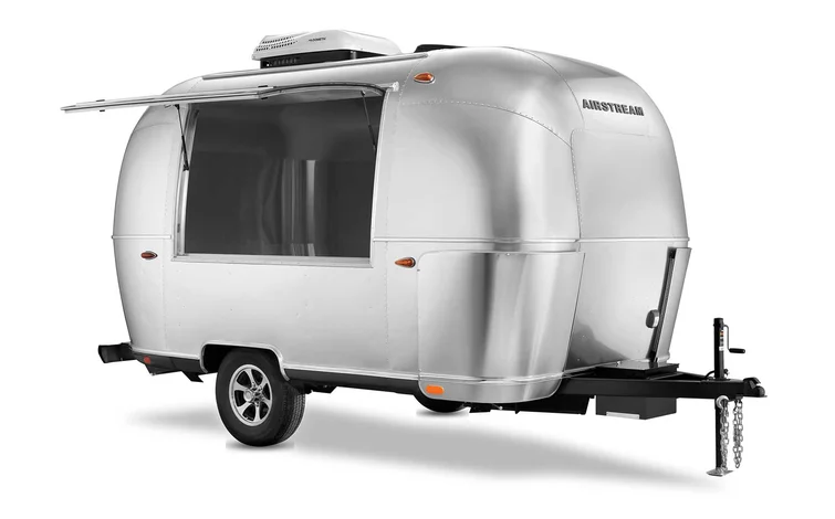 A sleek, silver Airstream 16-foot stock bar trailer with a curved design and an open serving window, set against a white background