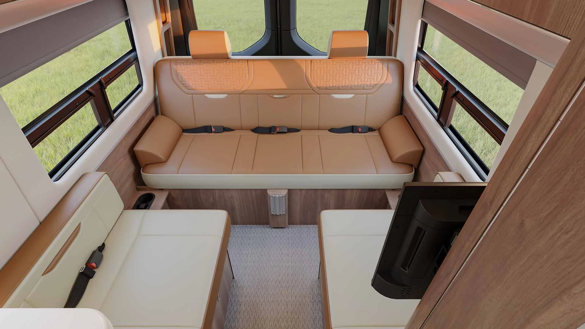 Interior of a camper van with beige leather seating, windows on both sides, and a TV mounted near the entrance.