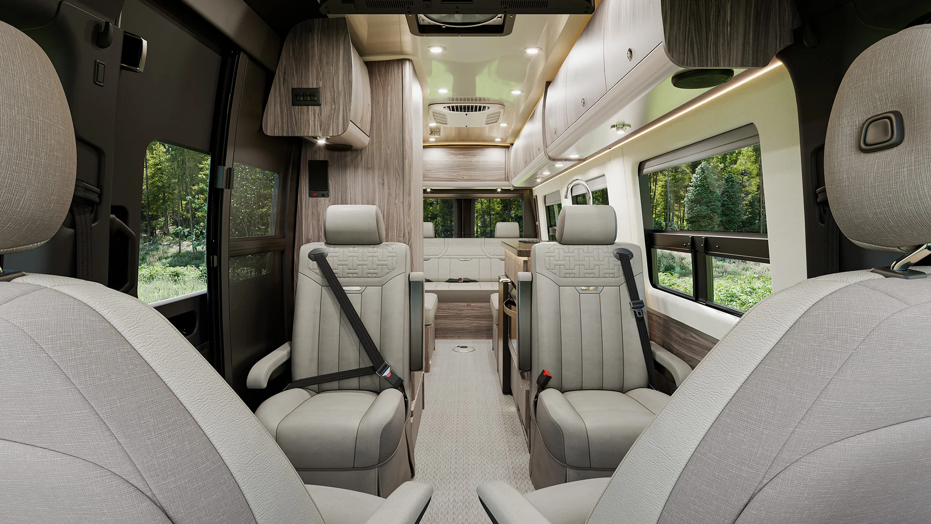 Luxurious van interior with beige leather seats, wood accents, overhead storage, and windows revealing a green forest view.