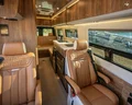 Dark amber-colored leather seats in front of a auburn-colored wood laminate galley