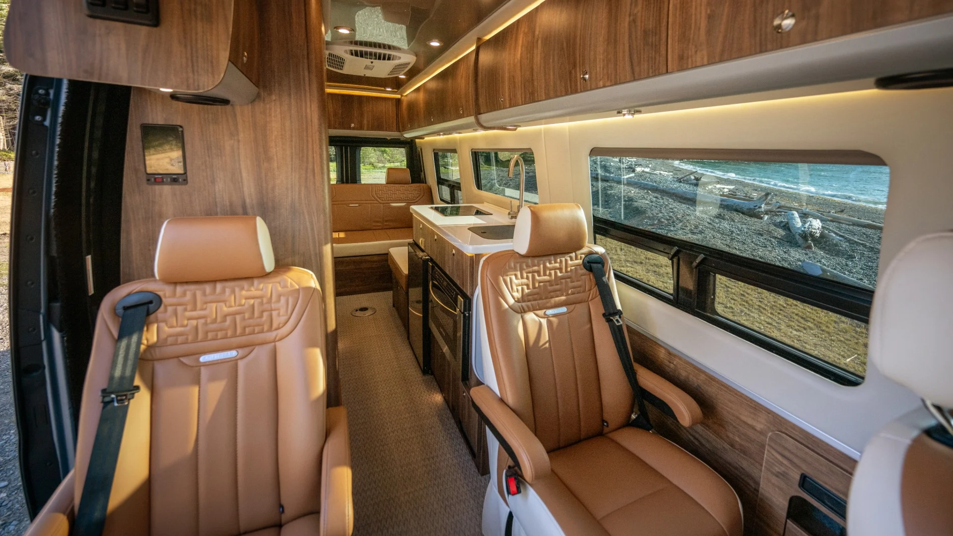 Dark amber-colored leather seats in front of a auburn-colored wood laminate galley