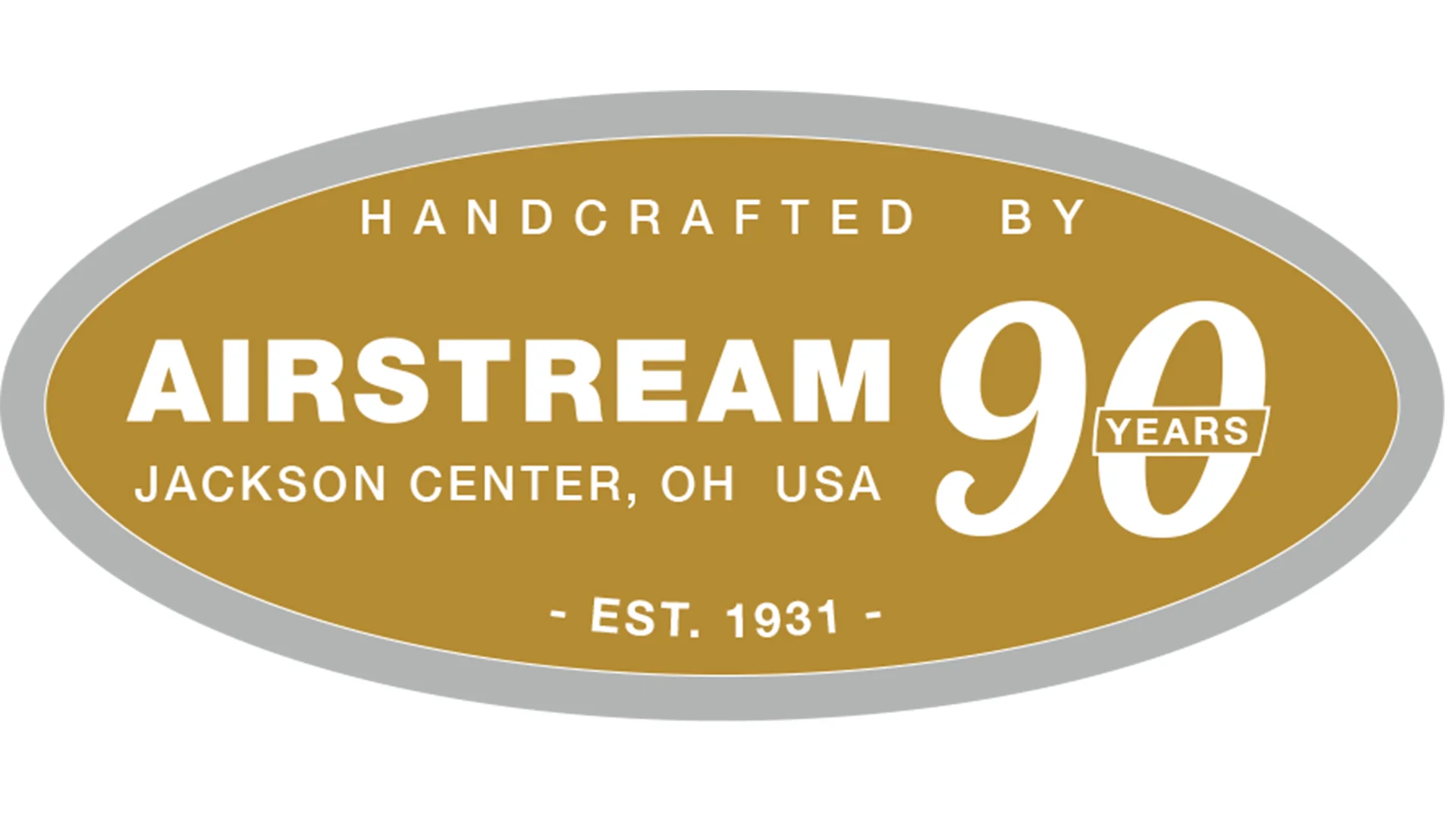 Gold oval badge with gray border. Text reads: Handcrafted by Airstream, Jackson Center, OH USA, 90 Years, Est. 1931. The number 90 features Years across it, celebrating Airstreams 90th anniversary.