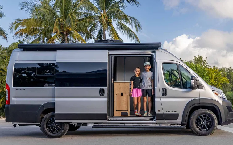 Kids standing at the curbside sliding door for the Rangeline 21PL Travel Van