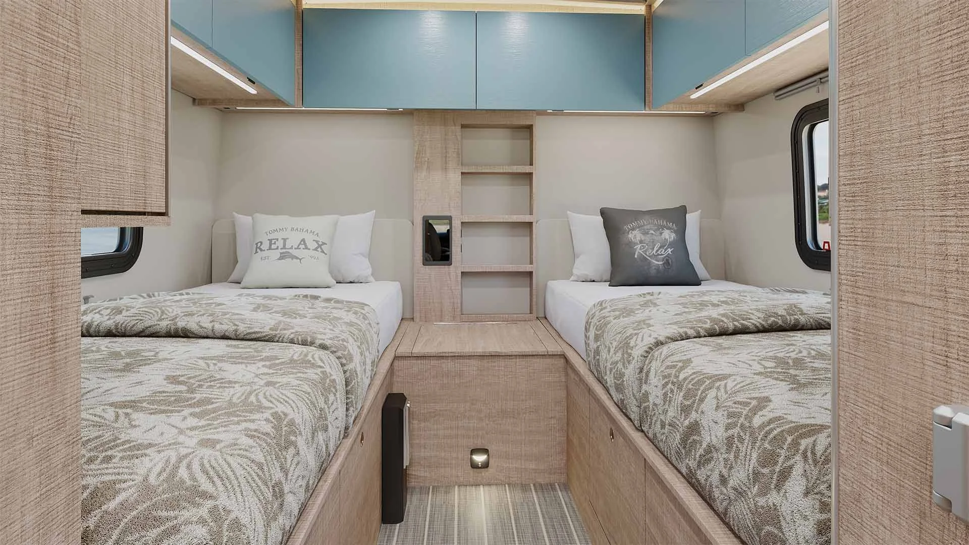 Compact bedroom with two single beds, floral bedding, and overhead storage in light wood tones, featuring windows on either side.