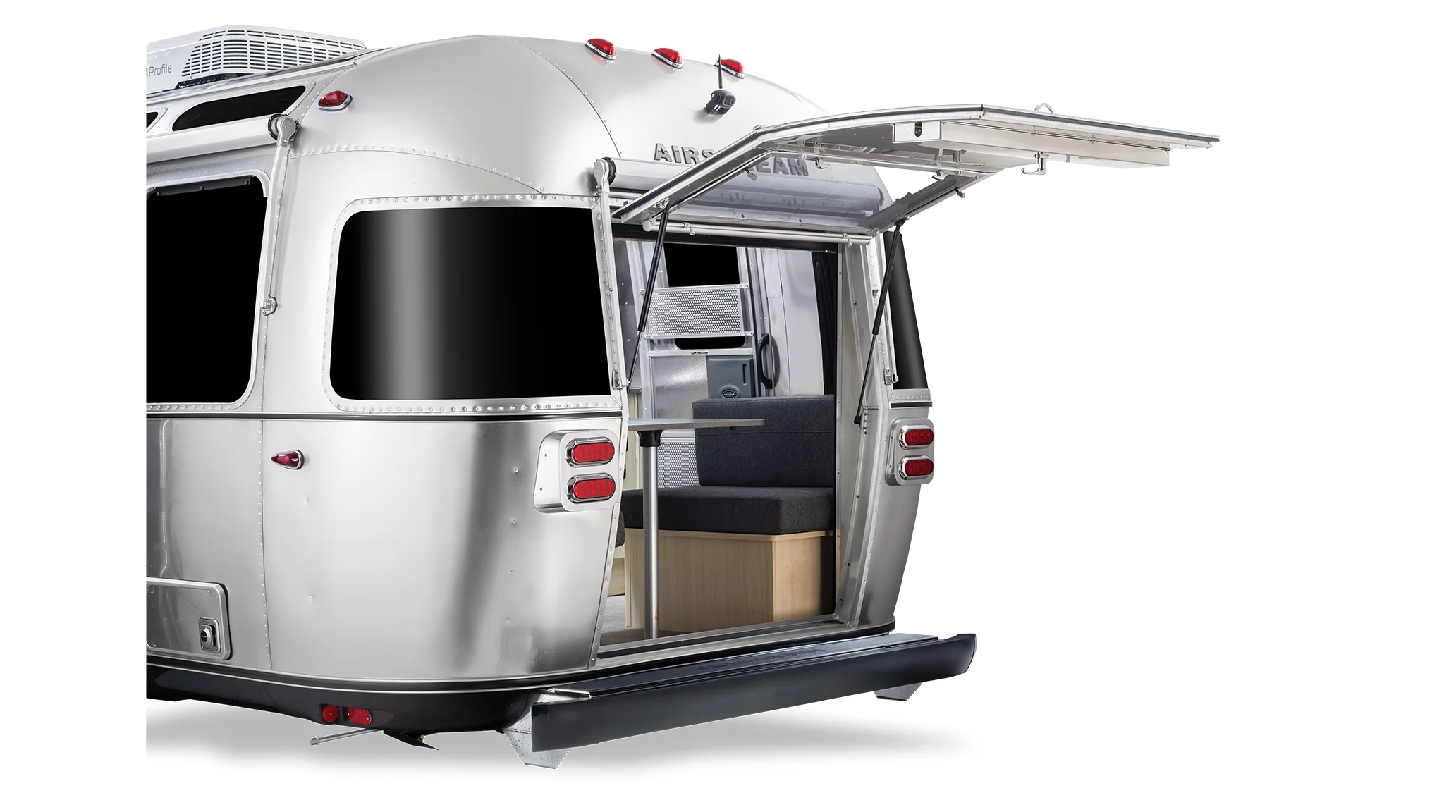 Airstream trailer with open rear hatch, silver exterior, visible interior seating, black windows, and roof-mounted air conditioning unit.