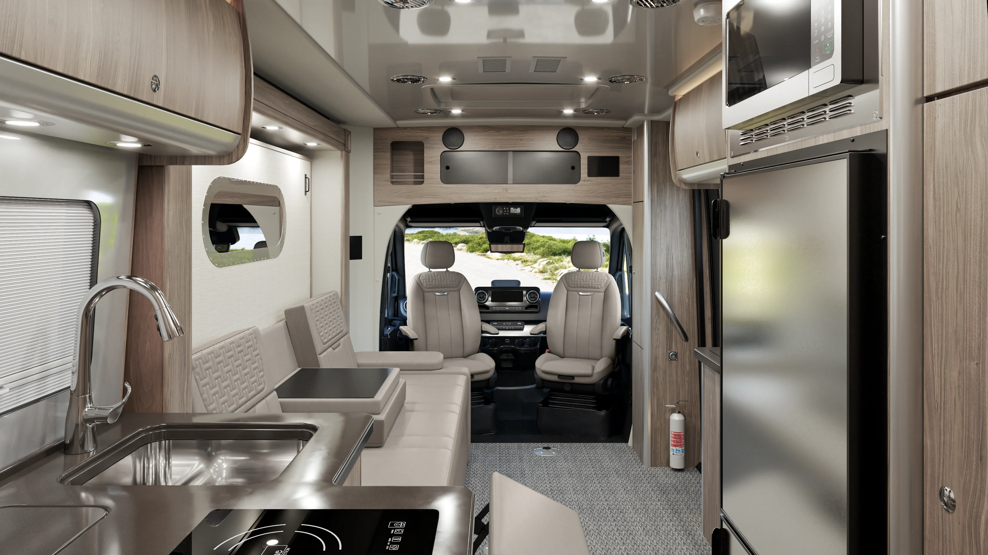 Modern camper van interior with light wood cabinetry, a stainless steel sink, stove, refrigerator, microwave, and two front captain’s chairs. Large windows provide natural light, creating a spacious and clean atmosphere.