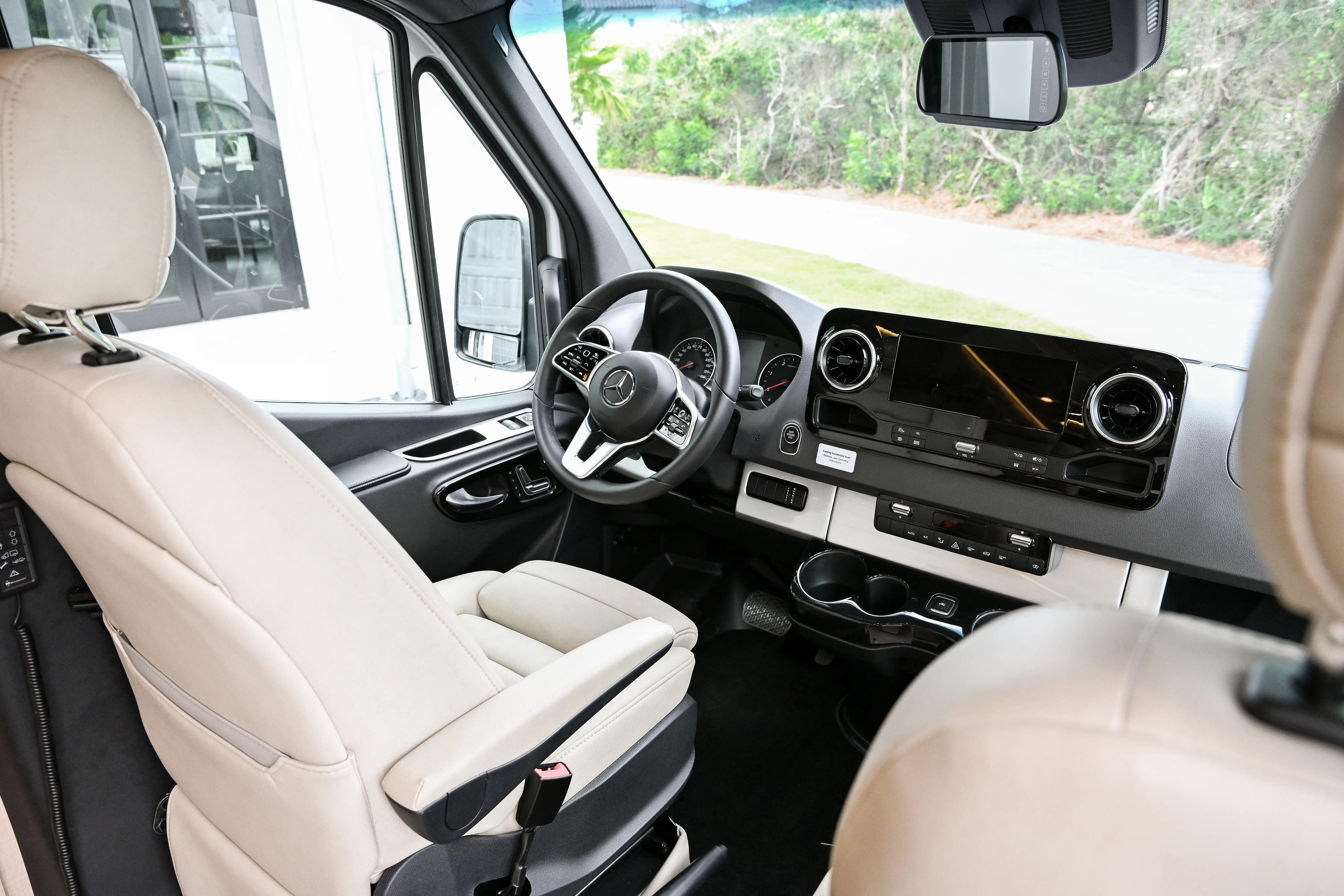 Cream-colored camper van front seats and Mercedez front dash